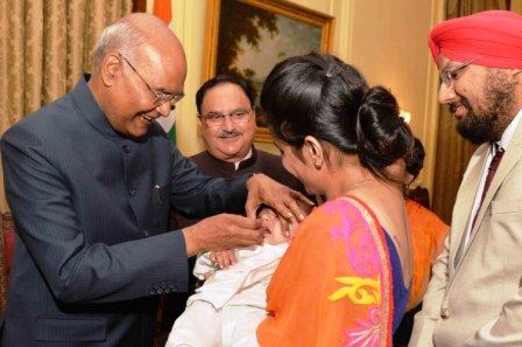 president delivers polio drug to children