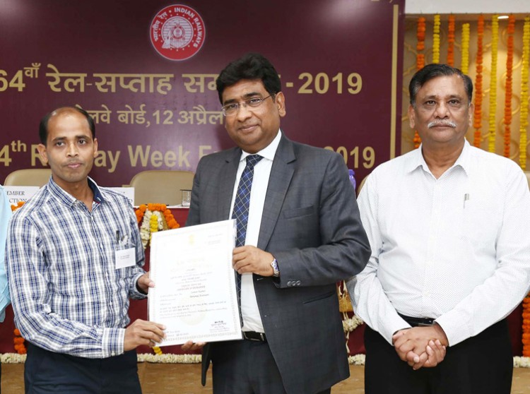 railway board chairman giving a certificate of excellence to the officers